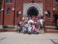 Foto rodiny syna Marie Machové a Leopolda Hanuse, tj. Leopolda Hanuse a jeho ženy Kristiny; foceno 14.7.2007 před kostelem v Brainard, Nebraska. Na vozíčku je paní Kristine Hanus-ová, uprostřed nad ní jsou paní Dorothy (dcera paní Kristine) a pan John Hainovi, vpravo v poslední řadě její bratr Arcibiskup Jerome Hanus